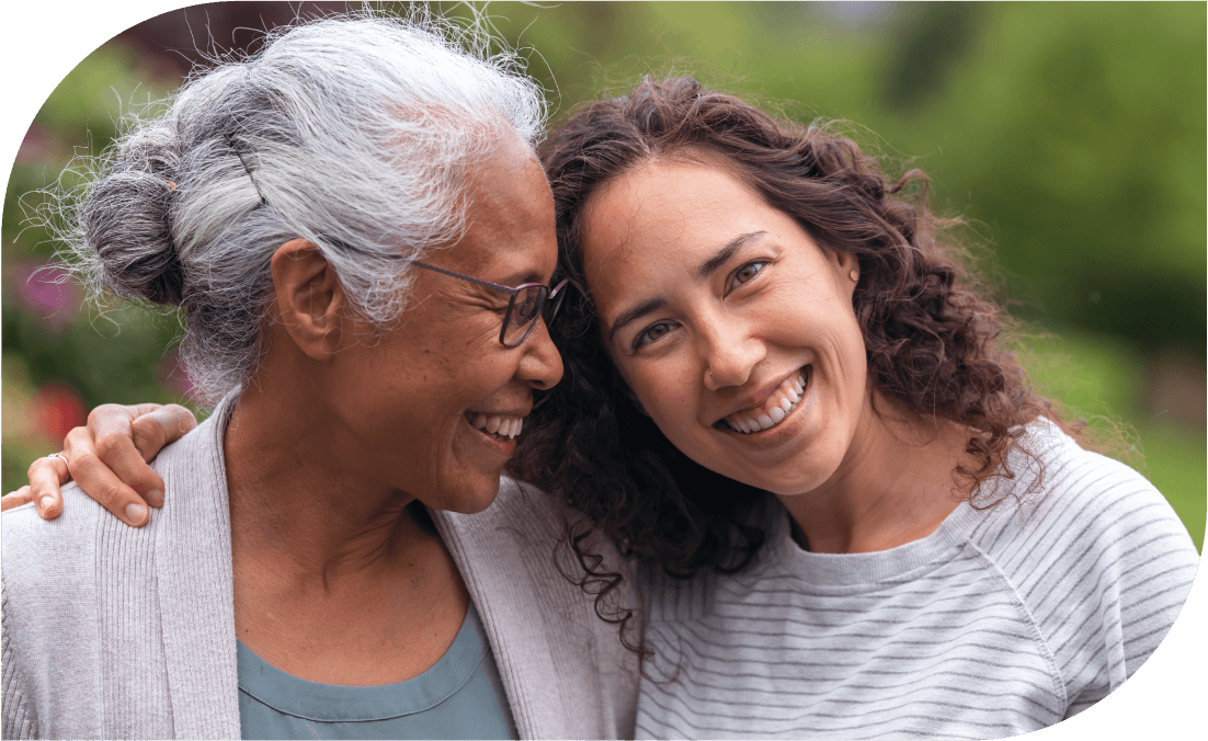 Older woman and younger woman smiling and embracing